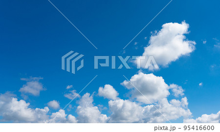 Panorama of a bright luminous blue sky with individual small white clouds 95416600