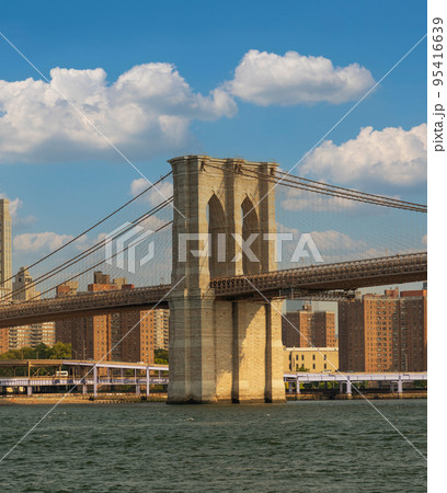 Brooklyn Bridge with a beautiful cloudy sky against the backdrop of Manhattan skyscrapers overlooking the East River 95416639