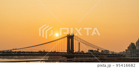 Manhattan Bridge at sunrise and some disc of the rising sun 95416682
