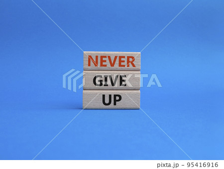 Never give up symbol. Concept words Never give up on wooden blocks. Beautiful blue background. Business and Never give up concept. Copy space. 95416916