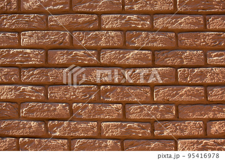 brown painted brick wall, retro style rough stone decorative facade texture close up view. 95416978