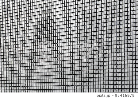 protective screen metal rectangular plates with rivets on the facade of the building with decorative pattern of gray stainless steel sheets, industrial architecture close-up details. 95416979