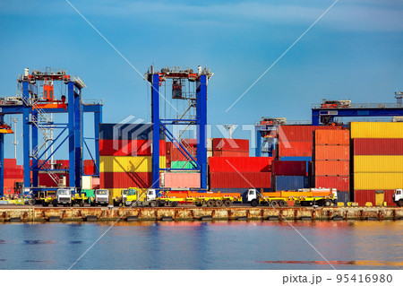long trucks in container depot in import and export area at port near sea port on warehouse colorful marine containers with gantry container cranes for loading freight to vehicle, nobody. 95416980