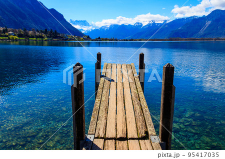 Wooden pier overlooking the Alps and Lake Geneva in Switzerland Wooden pier overlooking the Alps and Lake Geneva in Switzerland 95417035