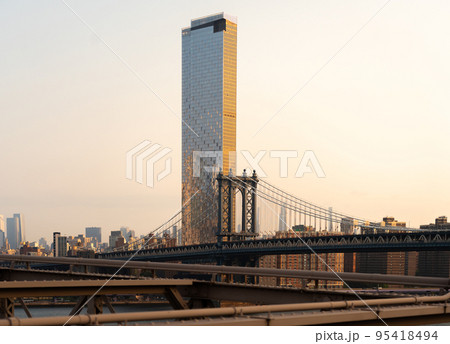 Manhattan bridge against the backdrop of morning New York and a tall skyscraper as a background Manhattan bridge against the backdrop of morning New York and a tall skyscraper as a background 95418494