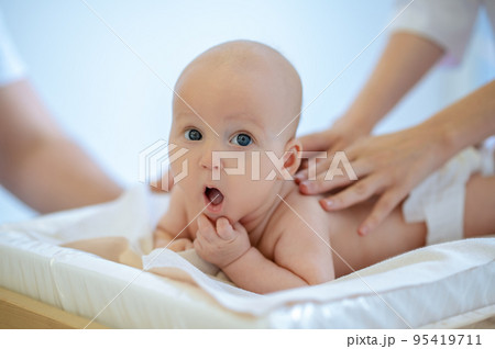 Cute baby being examined by pediatrician and looking surprised 95419711