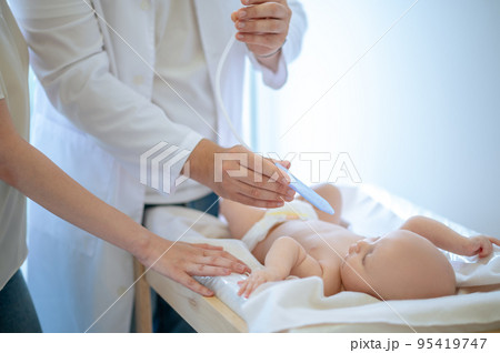 Pediatrician examining a baby at te clinic 95419747