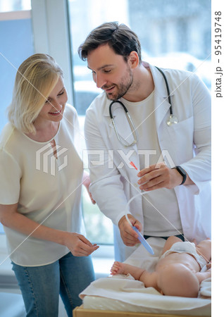 Pediatrician examining a baby at te clinic 95419748