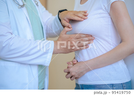 Experienced healthcare worker performing the breast examination 95419750