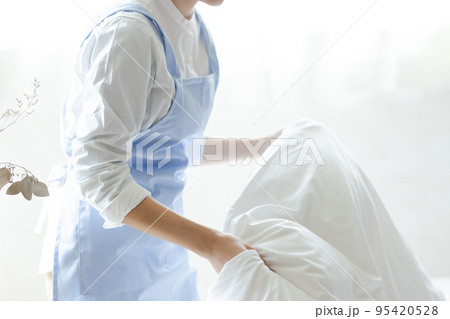 ベッドメイクをする可愛い女性 95420528