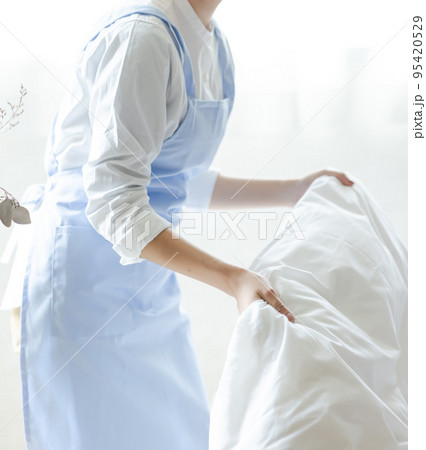 ベッドメイクをする可愛い女性 95420529