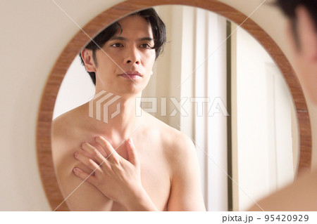 鏡を見ながら胸に手をあてる若い男性　メンズビューティー　イメージ 95420929