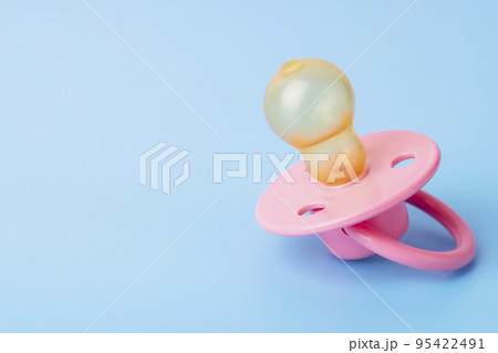 Orthodontic pacifier on a blue background. Pink baby pacifier Orthodontic pacifier on a blue background. Pink baby pacifier 95422491