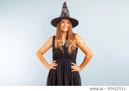 Happy brunette woman in halloween witch costume with black hat Happy brunette woman in halloween witch costume with black hat 95422511