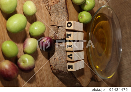Olives and Olive Oil on wooden background 95424476
