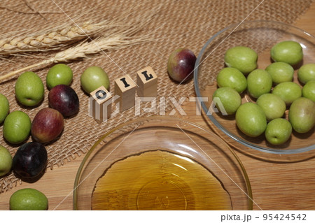Olives and Olive Oil on wooden background Olives and Olive Oil on wooden background 95424542