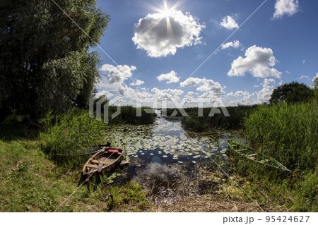 Summer lake with old boat 95424627