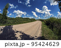 Beautiful summer gravel road with clouds 95424629