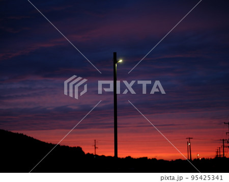 夏の終わりの夕焼け空と電灯 95425341