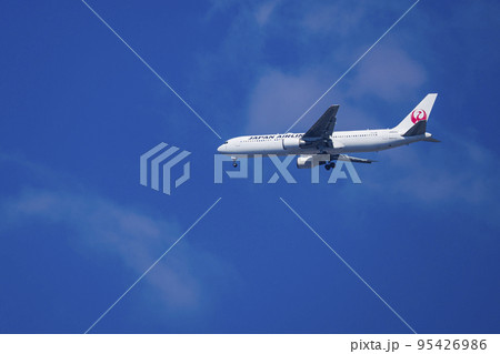 青空を滑空する旅客機 95426986