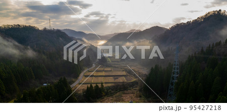 【ドローン撮影】山に囲まれた農村の朝｜幻想的な夜明けの朝霧イメージ 95427218