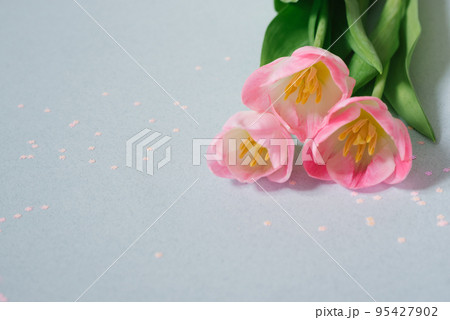 A bouquet of pink tulips on a soft blue background with pink confetti. Valentine's day, March 8, birthday, mother's day and Easter. Copy space A bouquet of pink tulips on a soft blue background with pink confetti. Valentine's day, March 8, birthday, mother's day and Easter. Copy space 95427902