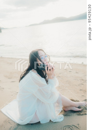海辺で電話をかける女性の写真 海辺で電話をかける女性の写真 95429130