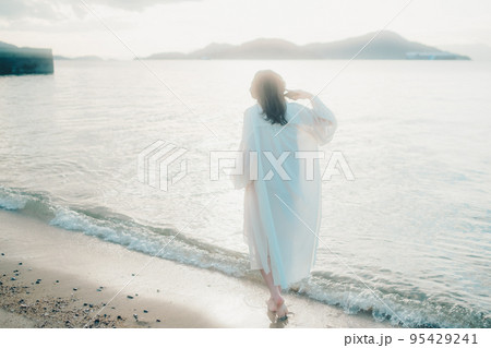 海辺で音楽を聴く女性の写真 95429241