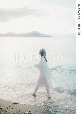 海辺で音楽を聴く女性の写真 95429370