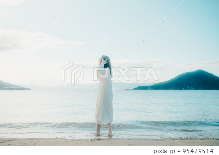 海辺で音楽を聴く女性の写真 海辺で音楽を聴く女性の写真 95429514