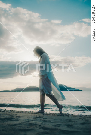海辺で音楽を聴く女性の写真 95429527