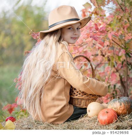 Girl in the hay with pumpkins Girl in the hay with pumpkins 95429698