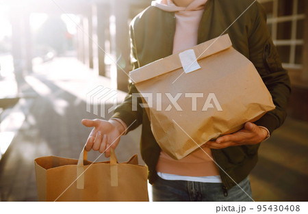 Courier delivers takeaway food and coffee. Delivery service in sity. Courier delivers takeaway food and coffee. Delivery service in sity. 95430408