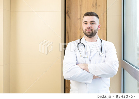 Portrait of young doctor man with medical instruments, smiling, looking at camera Portrait of young doctor man with medical instruments, smiling, looking at camera 95430757