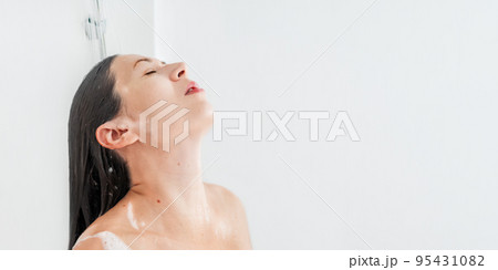 Naked woman with long hair takes a shower. Woman washes her hair with shampoo. Morning routine in modern urban apartment. White background with copy space. Naked woman with long hair takes a shower. Woman washes her hair with shampoo. Morning routine in modern urban apartment. White background with copy space. 95431082