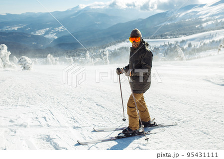 Man skiing in the mountains. Skiing in the snowy mountains, Winter is coming, snowfall. Active lifestyle. Man skiing in the mountains. Skiing in the snowy mountains, Winter is coming, snowfall. Active lifestyle. 95431111