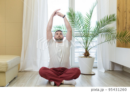 young man is engaged in yoga, fitness, sports at home online from a laptop, teaches, studies, quarantined, remotely, smiles, leads a healthy lifestyle young man is engaged in yoga, fitness, sports at home online from a laptop, teaches, studies, quarantined, remotely, smiles, leads a healthy lifestyle 95431260