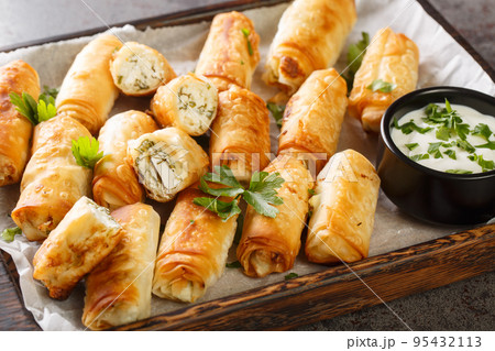 Sigara boregi Turkish snacks made from phyllo pastry, stuffed with feta cheese closeup on the wooden board. Horizontal Sigara boregi Turkish snacks made from phyllo pastry, stuffed with feta cheese closeup on the wooden board. Horizontal 95432113