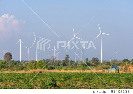 Wind turbines and solar panels in a big green field 95432158