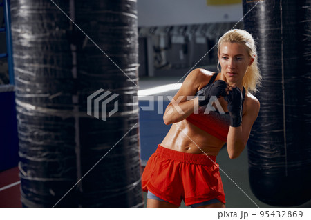 Sportive woman, female professional boxer training at sports gym, indoors. Sport, action, power, energy concept. Women in sport Sportive woman, female professional boxer training at sports gym, indoors. Sport, action, power, energy concept. Women in sport 95432869