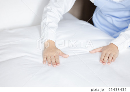 ベッドメイクをする可愛い女性 95433435