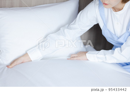 ベッドメイクをする可愛い女性 95433442
