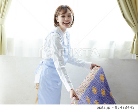 ベッドメイクをする可愛い女性 95433445