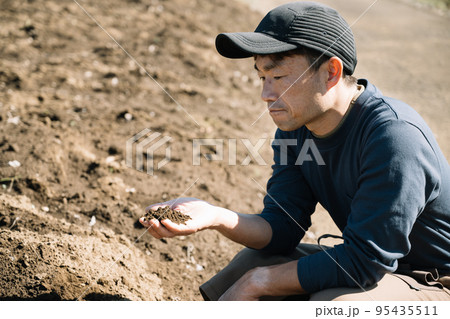 土を見る農家の男性 土を見る農家の男性 95435511