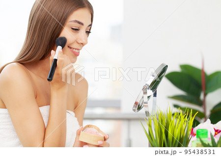 Young beautiful woman making make up near mirror Young beautiful woman making make up near mirror 95438531