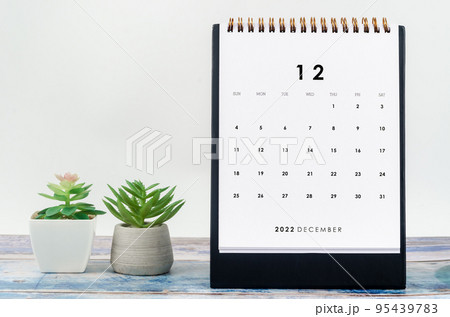 The December 2022 Monthly desk calendar for 2022 year with plant pot on old blue wooden background 95439783