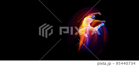 In miracle flight. Young sportive dancer in white clothes levitating, moving over dark background in mixed neon light. Creative art, aspiration, music, fashion, dance In miracle flight. Young sportive dancer in white clothes levitating, moving over dark background in mixed neon light. Creative art, aspiration, music, fashion, dance 95440734