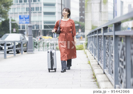 キャリーバックを引く女性 95442066