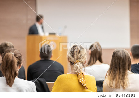 Speaker giving a talk in conference hall at business event. Rear view of unrecognizable people in audience at the conference hall. Business and entrepreneurship concept. Speaker giving a talk in conference hall at business event. Rear view of unrecognizable people in audience at the conference hall. Business and entrepreneurship concept. 95443191