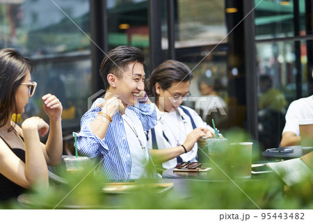 young asian adult friends gathering relaxing in outdoor coffee shop 95443482